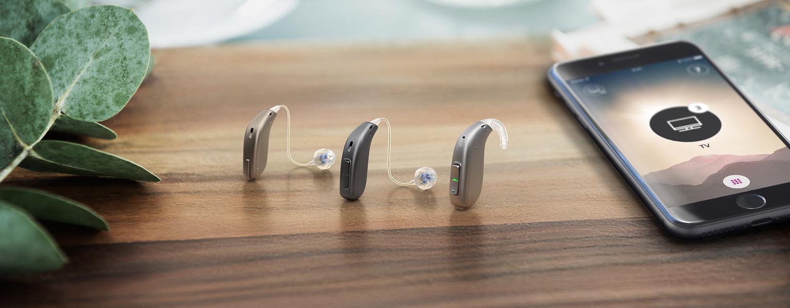 Oticon Hearing Aids sitting next to their Opn smartphone app
