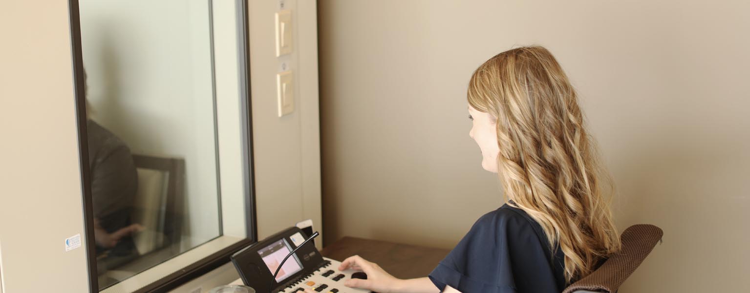 Audiologist Hailey Ainlay performing a hearing test